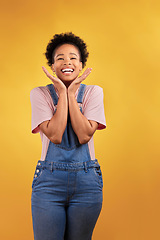 Image showing Wow, celebration and hands on face of black woman in studio happy for news, deal or promo on yellow background. Portrait, smile and African female winner excited for lottery, coming soon or bonus