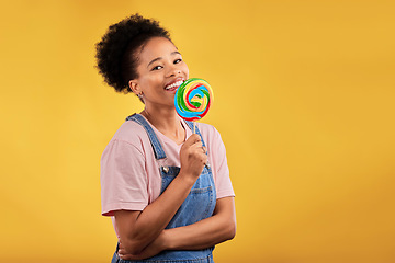 Image showing Happy, candy and portrait of a black woman with a lollipop on a studio background for food. Smile, mockup and an African girl or model with sweets for dessert isolated on a backdrop with space