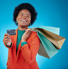 Image showing Woman, credit card and shopping bag for retail banking, finance and e commerce fintech or payment in portrait. Happy customer, fashion model or african person offer or debit on blue studio background