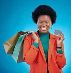 Image showing Credit card, shopping bag and woman in portrait for retail banking, finance and e commerce fintech or payment. Happy customer, fashion model or african person for debit pay on blue, studio background