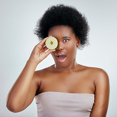 Image showing Skincare, apple and portrait of a woman in studio with a natural, organic and beauty face routine. Shock, wellness and African female model with slice of fruit for facial treatment by gray background