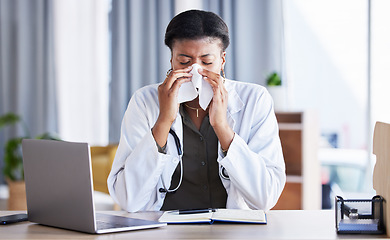 Image showing Sick, doctor and a black woman blowing nose in an office as a healthcare employee at a desk. Table, hospital and an African nurse or medical worker sneezing into a tissue with a virus or flu