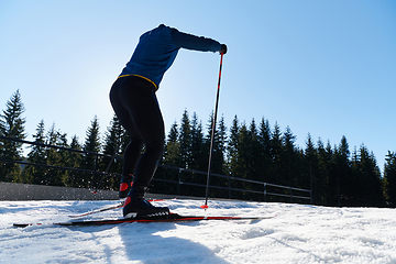 Image showing Nordic skiing or Cross-country skiing classic technique practiced by man in a beautiful panoramic trail at morning.Selective focus.