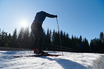 Image showing Nordic skiing or Cross-country skiing classic technique practiced by man in a beautiful panoramic trail at morning.Selective focus.