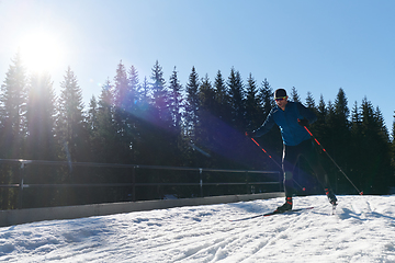 Image showing Nordic skiing or Cross-country skiing classic technique practiced by man in a beautiful panoramic trail at morning.Selective focus.