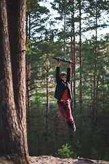 Image showing Teen boy at bungee in autumn forest