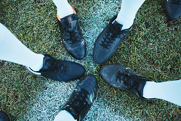 Image showing Soccer, sport shoes and teamwork with people together on a grass field for motivation or competition. Closeup, above and football player or athlete group on a pitch for training, exercise or fitness