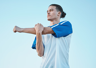 Image showing Soccer, fitness and stretching with a man on a blue sky background in preparation of a game or competition. Sports, health and warm up with a young male athlete getting ready for training or practice