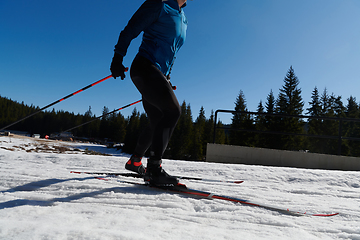 Image showing Nordic skiing or Cross-country skiing classic technique practiced by man in a beautiful panoramic trail at morning.Selective focus.