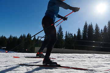 Image showing Nordic skiing or Cross-country skiing classic technique practiced by man in a beautiful panoramic trail at morning.Selective focus.