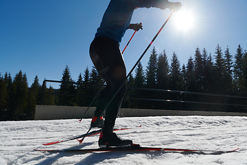 Image showing Nordic skiing or Cross-country skiing classic technique practiced by man in a beautiful panoramic trail at morning.Selective focus.