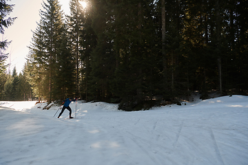 Image showing Nordic skiing or Cross-country skiing classic technique practiced by man in a beautiful panoramic trail at morning.Selective focus.