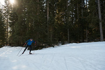 Image showing Nordic skiing or Cross-country skiing classic technique practiced by man in a beautiful panoramic trail at morning.Selective focus.