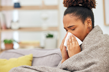 Image showing Sick, woman and blowing nose with blanket in home from hayfever allergies, cold and winter virus. Face, tissue and black female person sneeze from influenza allergy, health problem and sinusitis risk