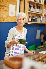 Image showing Made to order. Shot of a senior woman serving coffee in a cafe.