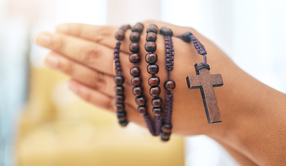 Image showing Rosary, praying and hands of woman with gratitude, faith or guidance in her home for help from Jesus christ. Christian, worship and female in prayer with trust, hope and spiritual praise or blessing