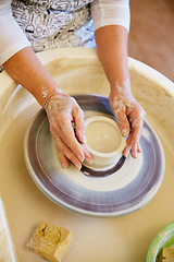 Image showing Working the wheel. Cropped shot of a woman making a ceramic pot in a workshop.