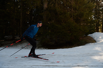 Image showing Nordic skiing or Cross-country skiing classic technique practiced by man in a beautiful panoramic trail at morning.Selective focus.