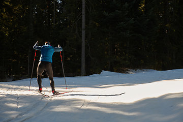 Image showing Nordic skiing or Cross-country skiing classic technique practiced by man in a beautiful panoramic trail at morning.Selective focus.