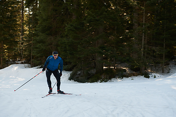 Image showing Nordic skiing or Cross-country skiing classic technique practiced by man in a beautiful panoramic trail at morning.Selective focus.