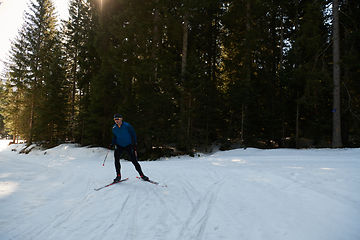 Image showing Nordic skiing or Cross-country skiing classic technique practiced by man in a beautiful panoramic trail at morning.Selective focus.