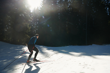 Image showing Nordic skiing or Cross-country skiing classic technique practiced by man in a beautiful panoramic trail at morning.Selective focus.