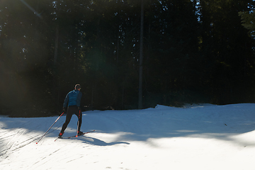 Image showing Nordic skiing or Cross-country skiing classic technique practiced by man in a beautiful panoramic trail at morning.Selective focus.