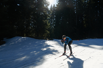 Image showing Nordic skiing or Cross-country skiing classic technique practiced by man in a beautiful panoramic trail at morning.Selective focus.