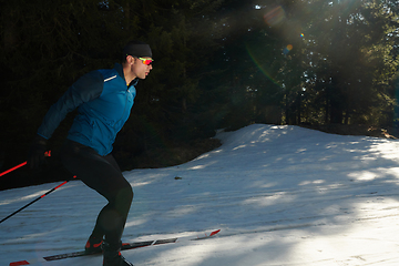 Image showing Nordic skiing or Cross-country skiing classic technique practiced by man in a beautiful panoramic trail at morning.Selective focus.