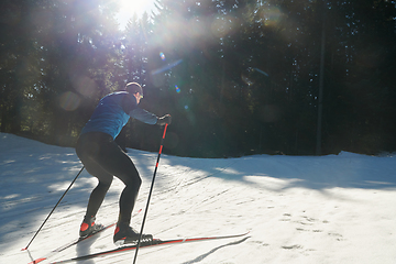 Image showing Nordic skiing or Cross-country skiing classic technique practiced by man in a beautiful panoramic trail at morning.Selective focus.