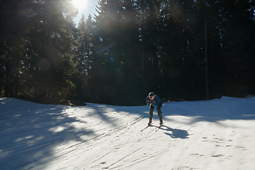 Image showing Nordic skiing or Cross-country skiing classic technique practiced by man in a beautiful panoramic trail at morning.Selective focus.