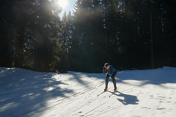 Image showing Nordic skiing or Cross-country skiing classic technique practiced by man in a beautiful panoramic trail at morning.Selective focus.