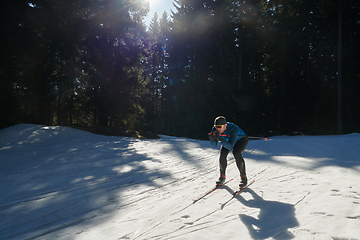 Image showing Nordic skiing or Cross-country skiing classic technique practiced by man in a beautiful panoramic trail at morning.Selective focus.