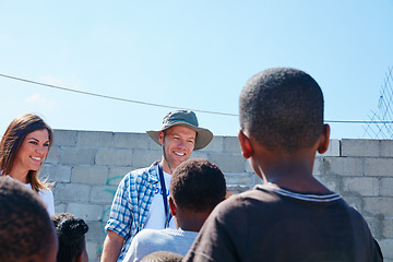 Image showing Sometimes your time is all they need. Shot of two volunteer workers addressing a group of kids at a community outreach event.