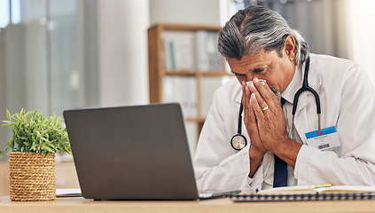 Image showing Sneezing, sick and a doctor with a laptop in an office, blowing nose and an allergy at a hospital. Healthcare, medicine and a mature medical employee with a tissue with covid or a virus at work