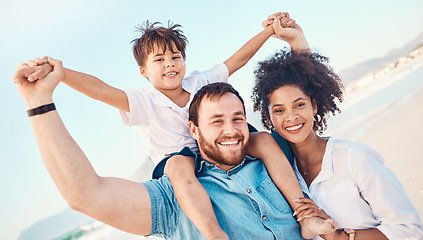 Image showing Mother, father and a child happy at the beach while on a vacation, holiday or adventure. A woman, man and kid on shoulders while together outdoor for summer fun and travel with multiracial family