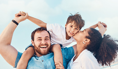 Image showing Beach, father and a mother kiss child on the cheek while on a vacation, holiday or adventure. A woman, man and kid on shoulders for a portrait outdoor of summer fun and travel with multiracial family