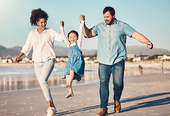 Image showing Happy family, swinging and a child at the beach on vacation, holiday or adventure in summer. Young girl kid holding hands and playing with parents outdoor with fun energy, happiness and love at sea