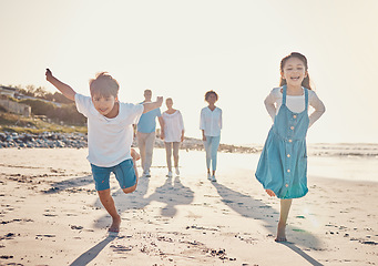 Image showing Happy, excited and children playing on the beach on family vacation, holiday or adventure in summer. Young girl and boy or kids and parents outdoor with fun energy and happiness while playing a game