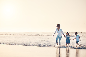 Image showing Playing, mother and children at beach on a fun family vacation, holiday or nature adventure at sunset. Young boy and girl holding hands with a woman outdoor for fun energy, happiness and banner space