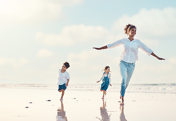 Image showing Mother, son and daughter on the beach to dance together while outdoor for travel or vacation in summer. Sunset, family or children and a woman having fun with her kids on the coast by the ocean