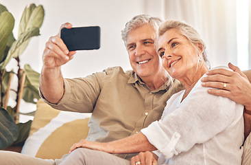 Image showing Happy senior couple, hug and selfie in relax on living room sofa for photograph, memory or vlog at home. Elderly man and woman smile for picture, photo or social media post on lounge couch together