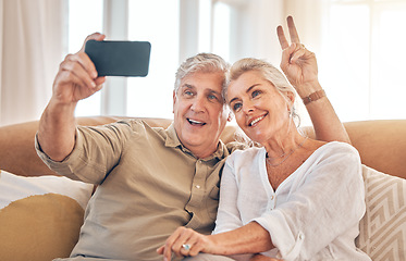 Image showing Happy senior couple, peace sign and selfie in relax on living room sofa for photograph, memory or vlog at home. Elderly man and woman smile for picture, photo or social media on lounge couch together