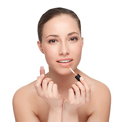 Image showing Giving her lips that extra touch. Studio portrait of a beautiful brunette applying lip gloss.