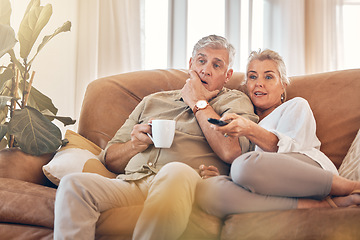 Image showing Senior couple, watching tv and sofa in relax for streaming, movie or series in living room at home. Elderly man and woman with coffee and remote together for changing channel and online entertainment