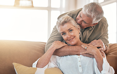 Image showing Senior, portrait and a couple kiss and hug on the living room sofa for love, care and bonding. Happy, house and an elderly man and woman with romance together for gratitude, retirement and kindness