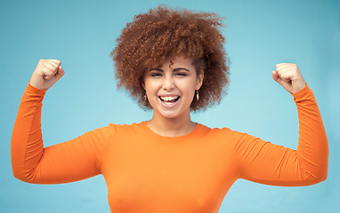 Image showing Portrait, strong and bicep with a black woman in studio on a blue background flexing her muscle for empowerment. Face, equality and power with an attractive young female posing to promote health