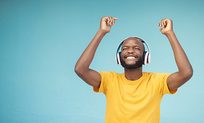 Image showing Music, dance and mockup with a black man in studio on a blue background wearing headphones. Radio, freedom and fun with a male dancing indoor alone while streaming an online audio playslist