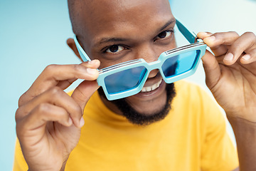 Image showing Black man, sunglasses and comic face portrait on blue background with cool and trendy style or fashion. Happy young model person with glasses in studio for advertising designer brand, logo or color