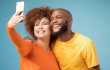 Image showing Couple, hug or bonding selfie on blue background, isolated mockup or wall mock up for social media. Smile, happy or black man and afro woman on photography technology for interracial profile picture